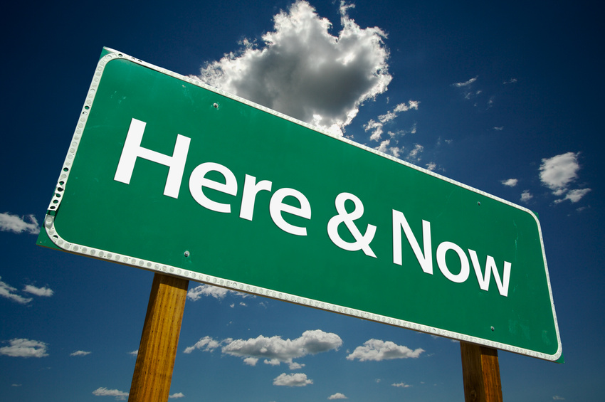 "Here & Now" Road Sign with dramatic clouds and sky.